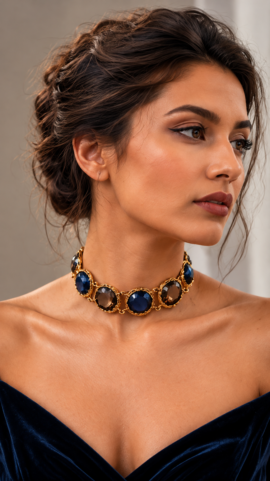 Medoso Jewellery statement choker featuring deep navy blue and smoky brown faceted gemstones in ornate antique gold-toned settings, styled on a model in a navy velvet outfit from the Desert Heirloom Collection.